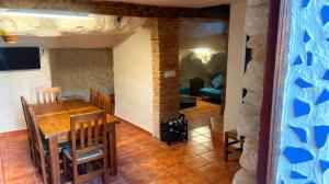 comedor con mesa y sala de estar en Casa Cueva Toni, en Alcalá del Júcar
