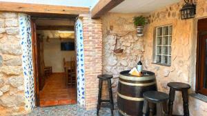 una habitación con barril de vino y taburetes en Casa Cueva Toni, en Alcalá del Júcar