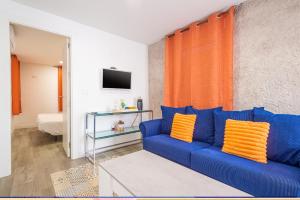 a blue couch with orange pillows in a living room at Att Cartagena Centro Histórico in Cartagena