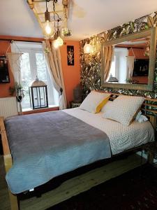 een slaapkamer met een groot bed en een grote spiegel bij Clos Germanois in Saint-Germain-Laval