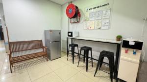 a kitchen with a counter with stools and a refrigerator at Best View Hotel Bandar Sunway in Petaling Jaya