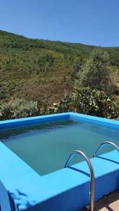 uma grande piscina azul com uma colina ao fundo em Casa da Volta - Alentejo - S. Julião em Portalegre