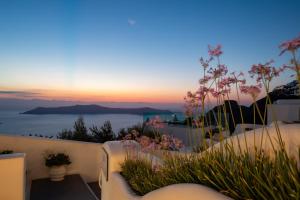 een uitzicht op de zonsondergang vanaf het balkon van een huis bij Santorini View Studios - Firostefani Caldera in Firostefani