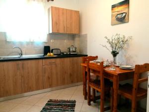 eine Küche mit einem Holztisch und einem Esszimmer in der Unterkunft Nikos Apartments 2 in Kavos