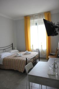 a bedroom with two beds and a table and a tv at Dolce Titina Affittacamere in Rome