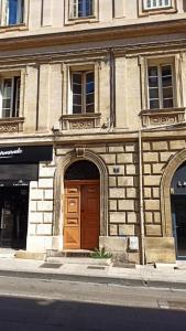 un edificio con porta in legno su una strada cittadina di L' Appart du Centre Historique Charme et confort a Arles