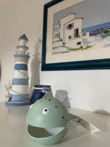 figurka ryby i latarnia morska na stole w obiekcie Casa Marina w mieście Carloforte