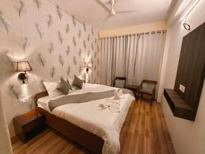 a bedroom with a bed and a wall with leaves on it at Vibes by Vicctoria House in McLeod Ganj