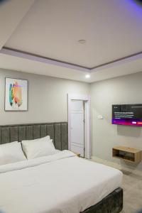 um quarto com uma cama e uma televisão na parede em Plot 100 em Lagos
