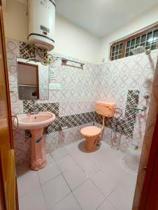 a bathroom with a pink toilet and a sink at Vibes by Vicctoria House in McLeod Ganj