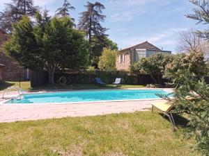 a swimming pool in the backyard of a house at L'Atelier de Pierre Gîte Atypique in Saint-Cyr