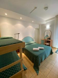 two twin beds in a room with a mirror at CASA MAJOR Hotel & Appartamenti CERVIA in Cervia