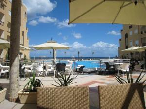 a pool with chairs and tables and an umbrella at Studio S0 FOLLA RESORT CHATT MERIEM in Sousse