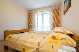 ein Schlafzimmer mit einem Bett mit gelber Decke und einem Fenster in der Unterkunft Ferienwohnung für 3 Personen ca 35 m in Njivice, Kvarner Bucht Krk in Njivice