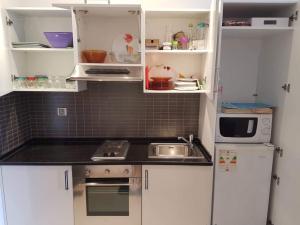 a small kitchen with white cabinets and a sink at Studio S0 FOLLA RESORT CHATT MERIEM in Sousse