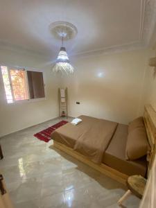- une chambre avec un grand lit et un lustre dans l'établissement Surf Bliss tamraght, à Tamraght Ouzdar