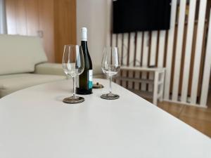 een fles wijn en twee wijnglazen op een tafel bij Nr1 White appartment w Luxury BA between Train St. and DT in Larisa