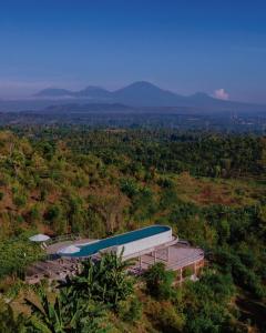 a building on top of a hill in a field at Sumberkima Hill Retreat in Pemuteran
