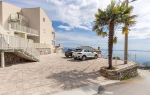 a car parked next to a building with a palm tree at Apartman 2A in Breza
