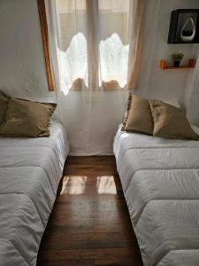 2 camas en una habitación pequeña con ventana en Villa Richmond, en Gran Alacant
