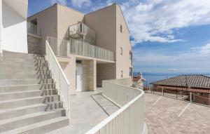 a white house with stairs and a view of the ocean at Apartman 2A in Breza