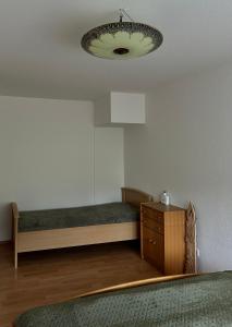 a room with a bed and a dresser and a lamp at Westfalenpark Apartment with terrace and free parking in Dortmund