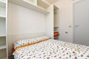 um quarto com uma cama com uma parede branca em Ferienwohnung für 4 Personen ca 45 qm in Piovere, Gardasee Westufer Gardasee em Piovere