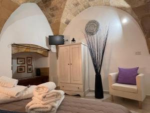 a room with a bed and a chair and a tv at Stella del Barocco in Lecce