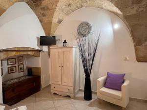 Zimmer mit einem Stuhl, einem TV und einer Vase in der Unterkunft Stella del Barocco in Lecce