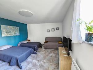 CustinesにあるGîte Les Amandiersの青い壁の客室で、ベッド2台とソファが備わります。
