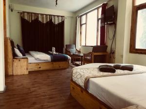 a bedroom with two beds and a table and chairs at DevDham Lodge in Chandīgarh