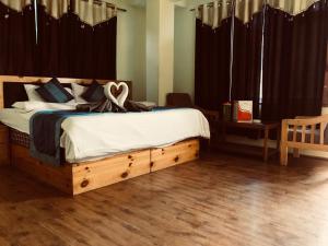 a bedroom with a large bed with a wooden frame at DevDham Lodge in Chandīgarh