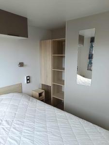 una camera con letto bianco e specchio di Mobilhome Baltique a Oye-Plage