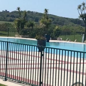 uma piscina com uma cerca preta e uma piscina em Appartement de luxe urrgne em Urrugne