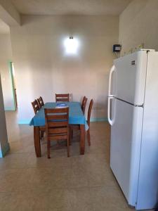 a kitchen with a table and a white refrigerator at You 4 Ric Apartment 2: Fully-furnished 2-bedroom in Choiseul