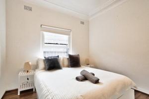 1 dormitorio con 1 cama blanca grande y ventana en Charming 3 Bedroom on the edge of Downtown Herford St 2 E-Bikes Included en Sídney
