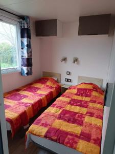 two beds sitting next to each other in a bedroom at Mobilhome Baltique in Oye-Plage