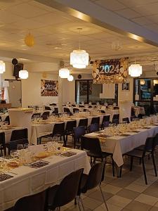 una stanza piena di tavoli e sedie con lenzuola bianche di Mobilhome Baltique a Oye-Plage