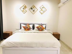 a bedroom with a large white bed with pillows at Hotel The Shan Exotica in Bhopal