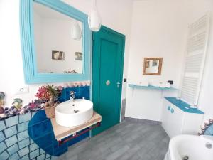 baño con puerta azul y lavamanos en Villa Mondello Terraces & Jacuzzi en Mondello