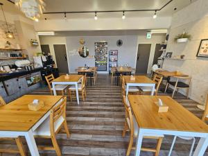 a restaurant with wooden tables and chairs and a kitchen at Gyeongju BonghwangMansion in Gyeongju