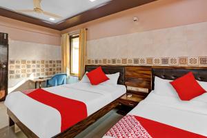 a hotel room with two beds and a chair at OYO Flagship Hotel Pakeeza in Mumbai