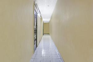 an empty hallway with a white wall and a tile floor at OYO Flagship Hotel Pakeeza in Mumbai