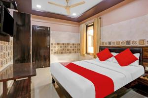 a bedroom with a large bed with red pillows at OYO Flagship Hotel Pakeeza in Mumbai