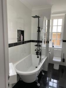 a white bathroom with a tub and a toilet at Beautiful 58 sqm Apartment Zone 2 in London