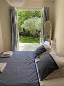 Schlafzimmer mit einem Bett und einem großen Fenster in der Unterkunft Les marguerites in Vers-Pont-du-Gard