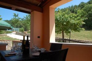 una mesa con botellas de vino y copas en un patio en Ferienwohnung für 1 Personen 3 Kinder ca 60 qm in Apecchio, Marken Provinz Pesaro-Urbino en Apecchio
