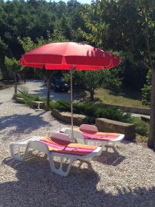 2 sillones y una sombrilla roja en Ferienwohnung für 1 Personen 3 Kinder ca 60 qm in Apecchio, Marken Provinz Pesaro-Urbino en Apecchio