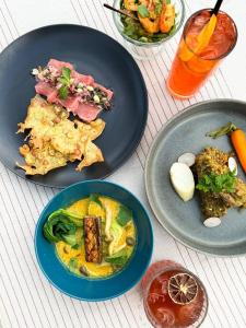 a table with plates of food and a drink at Sumberkima Hill Retreat in Pemuteran