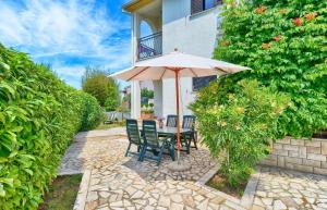 une table et des chaises avec un parasol sur une terrasse dans l'établissement Ferienwohnung für 4 Personen ca 35 qm in Fažana, Istrien Istrische Riviera, à Valbandon